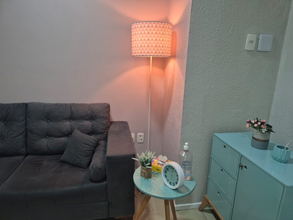 Sala de atendimento psicológico mobiliada, com sofá, iluminação acolhedora e ambiente climatizado no Instituto Gaspar Bandeira em Fortaleza.